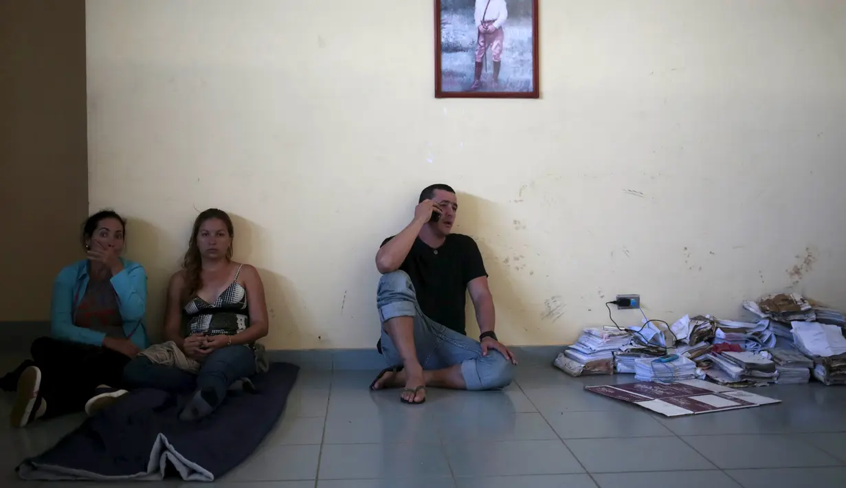 Imigran Kuba tampak menelpon di luar gedung bea cukai di perbatasan antara Nikaragua dan Kosta Rika, Minggu (15/11). Nikaragua menutup perbatasannya dengan Kosta Rika hingga ribuan orang yang menuju Amerika terlantar. (REUTERS/Oswaldo Rivas)