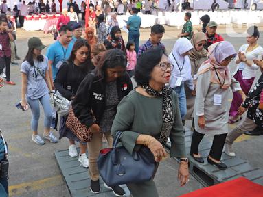 Anggota keluarga korban jatuhnya pesawat Lion Air JT 610 menaiki kapal KRI Semarang 594 di Dermaga JICT 2 Tanjung Priok, Jakarta, Selasa (29/10/2019). Mengenang setahun jatuhnya pesawat rute Jakarta-Pangkal Pinang itu, mereka melakukan tabur bunga di perairan Karawang. (Liputan6.com/Herman Zakharia)