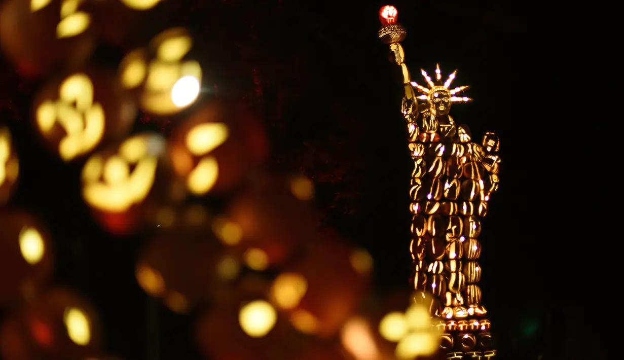 Labu berbentuk Patung Liberty yang disinari cahaya pada pameran Great Jack O'Lantern Blaze di Van Cortlandt Manor, New York, Sabtu (14/10). The Great Jack O'Lantern Blaze ini dipamerkan selama 25 hari pada Oktober - awal November. (TIMOTHY A. CLARY/AFP)