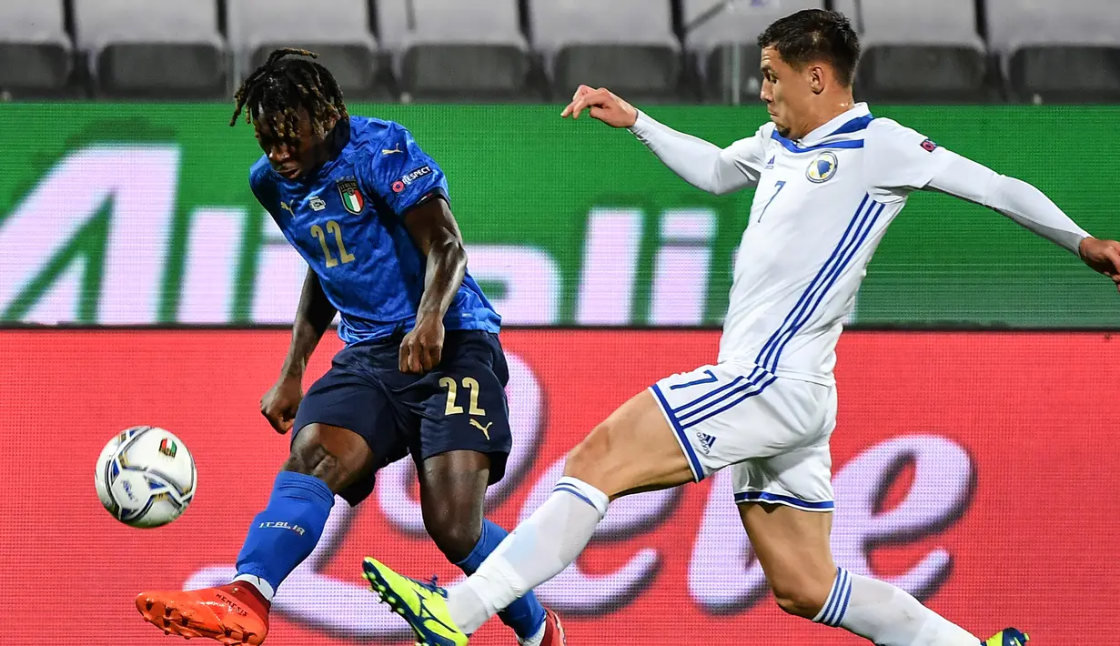 Penyerang Italia, Moise Kean, berebut bola dengan gelandang Bosnia, Muhamed Besic, pada laga UEFA Nations League di  Artemio Franchi, Sabtu (5/9/2020) dini hari WIB. Italia bermain imbang 1-1 atas Bosnia. (AFP/Isabella Bonotto)