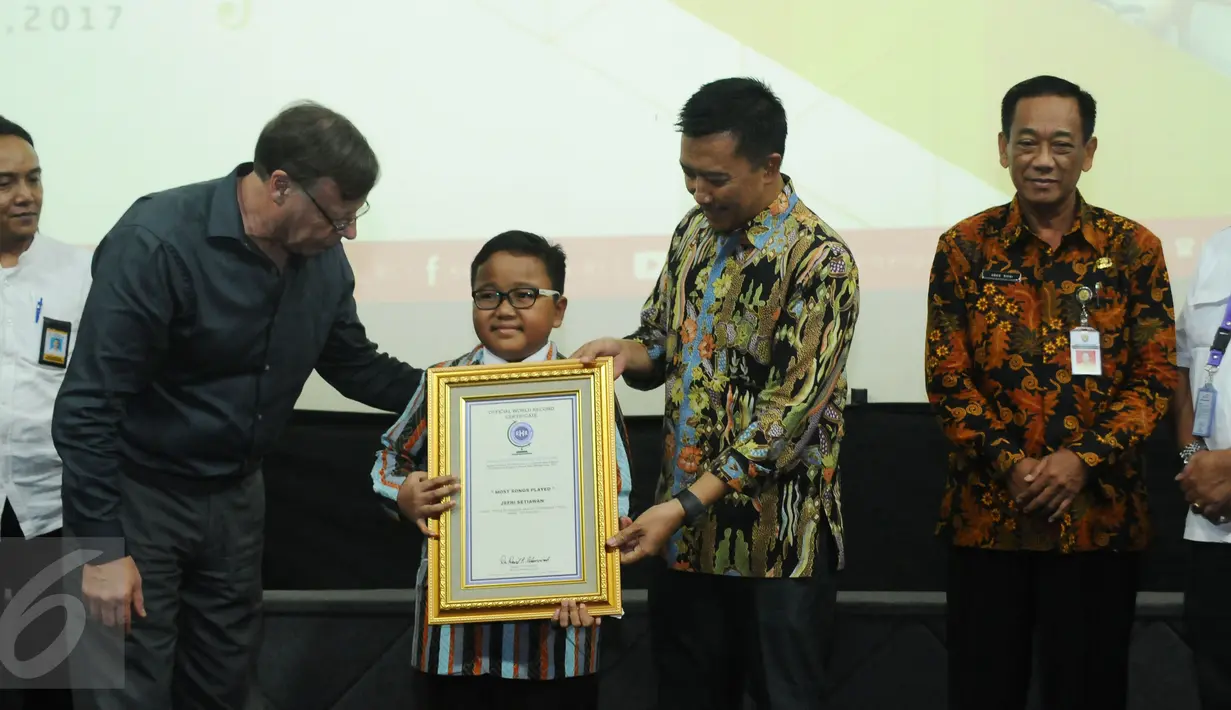 USA President Record Holders Republic, David Adamovich (kedua kiri) memberikan Official World Record Certificate kepada Jefri Setiawan yang berhasil mencatat rekor dunia di Auditorium Kemenpora, Jakarta, Kamis (14/11). (Liputan6.com/Helmi Fithriansyah)
