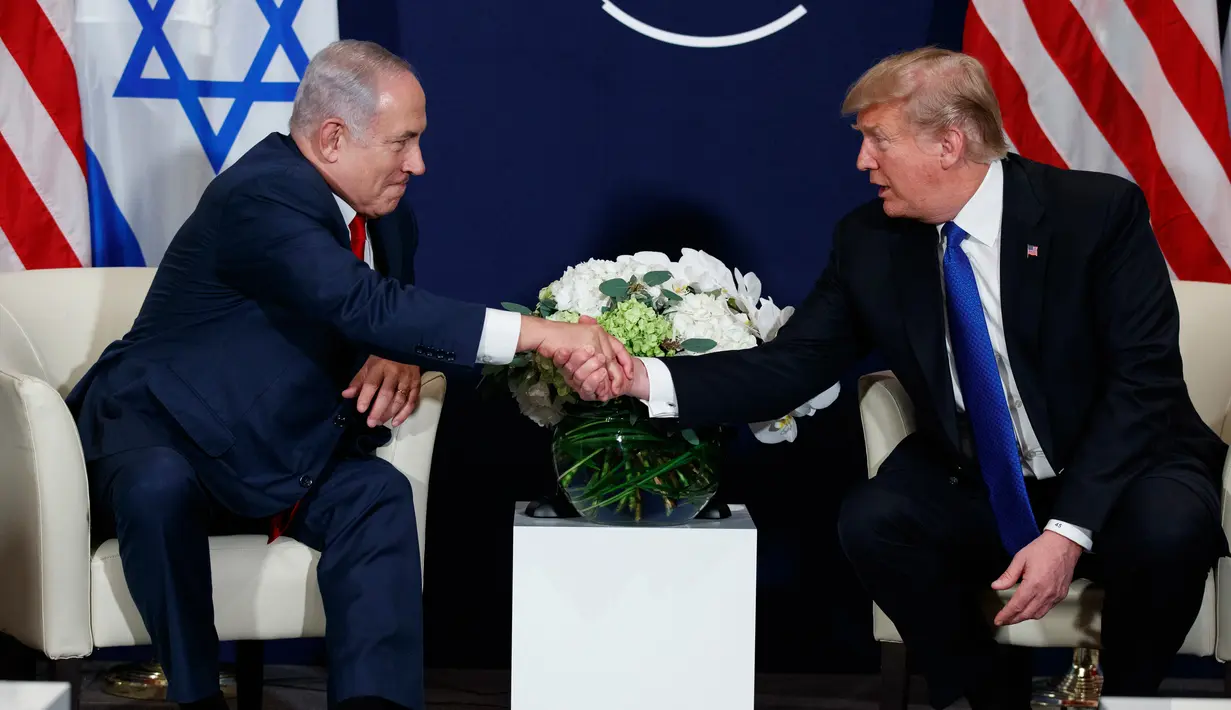 Presiden AS Donald Trump berjabat tangan dengan Perdana Menteri Israel Benjamin Netanyahu saat bertemu di sela Forum Ekonomi Dunia, Davos (25/1). (AP Photo / Evan Vucci)