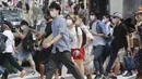 Orang-orang yang memakai masker untuk membantu melindungi diri dari penyebaran virus corona berjalan melintasi persimpangan di Tokyo, Senin (30/8/2021). Total nasional, Jepang mencatatkan 1,4 juta kasus dan 15.851 kematian akibat COVID-19. (AP Photo/Koji Sasahara)