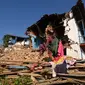 Seorang korban selamat mencari barang-barang di antara reruntuhan rumahnya yang rusak di Khalanga, distrik Jajarkot, pada tanggal 6 November 2023. (PRAKASH MATHEMA/AFP)