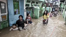 Warga menyusuri banjir yang merendam permukiman di Kebon Pala, Jakarta, Senin (8/2/2021). Banjir di Kebon Pala terus meninggi pada dini hari tadi hingga mencapai ketinggian 2,5 meter.  (merdeka.com/Iqbal S. Nugroho)