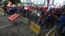 Pengunjuk rasa dari berbagai elemen buruh berusaha menerobos kawat berduri dalam aksi unjuk rasa di kawasan Patung Kuda, Jakarta, Rabu (8/12/2021). Dalam aksinya tersebut mereka meminta pemerintah dan DPR mencabut Undang-undang Nomor 11 Tahun 2020 tentang Cipta Kerja. (merdeka.com/Imam Buhori)