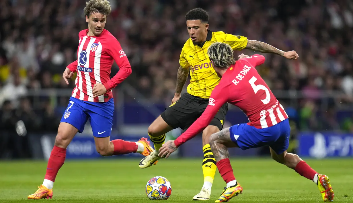 Pemain Atletico Madrid, Rodrigo De Paul, berusaha mengadang pemain Borussia Dortmund, Jadon Sancho, pada leg pertama perempat final Liga Champions di Stadion Metropolitano, Kamis (11/4/2024). (AP Photo/Manu Fernandez)