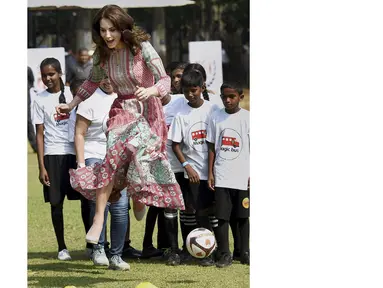 Istri Pangeran William, Catherine Middleton bermain bola bersama anak-anak di Mumbai, India, Minggu (10/4/2016). (Reuters/Mitesh Bhuvad/Pool)