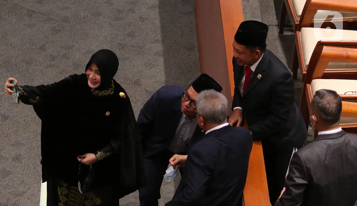 Menteri Dalam Negeri Tito Karnavian berfoto disela rapat paripurna ke-26 masa persidangan V tahun 2021-2022 di Kompleks Parlemen, Senayan, Jakarta, Kamis, (30/6/2022). DPR secara resmi mengesahkan tiga Rancangan Undang-Undang (RUU) tentang Daerah Otonomi Baru (DOB) menjadi UU, terkait pemekaran wilayah di Provinsi Papua. (Liputan6.com/Angga Yuniar)