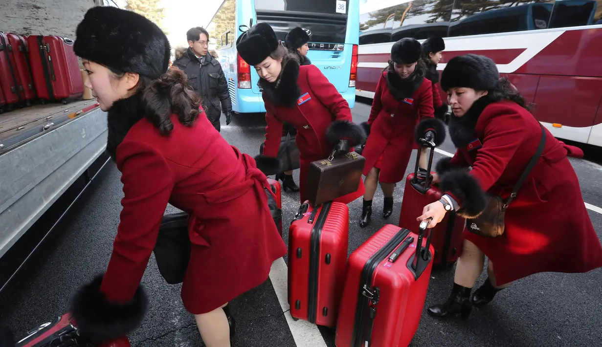 Tim pemandu sorak Korea Utara memasukan koper ke dalam bus saat tiba kantor transit Korea di dekat Zona Demiliterisasi di Paju, Korea Selatan, (7/2). (AP Photo/Ahn Young-joon. Pool)