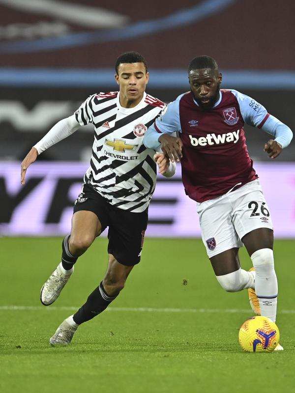 Pemain West Ham, Arthur Masuaku membawa bola dari kejaran gelandang Manchester United, Mason Greenwood pada pertandingan lanjutan Liga Inggris di stadion London di London, Inggris, Minggu (6/12/2020). MU menang 3-1 atas West Ham. (Justin Setterfield/Pool Via AP)