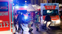 Tim regu penyelamat berada di lokasi dimana truk menabrak kerumunan orang di sebuah pasar Natal di pusat Kota Berlin, Jerman, Senin (19/12). Ambulan dan kendaraan aparat keamanan sesaat kemudian bermunculan di lokasi kejadian. (REUTERS/Pawel Kopczynski)