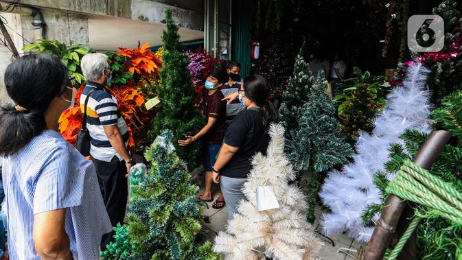 Warga membeli replika pohon Natal di Pasar Asemka, Jakarta, Rabu (16/12/2020). Warga Ibu kota, biasanya mencari pernak pernik Natal, seperti pohon Natal yang biasanya dari pohon pinus buatan. (Liputan6.com/Johan Tallo)