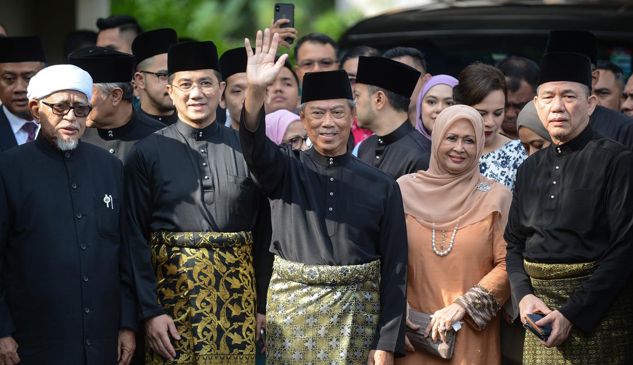 Muhyiddin Yassin (tengah) melambaikan tangan sebelum upacara pelantikannya sebagai Perdana Menteri Malaysia di Istana Negara, Kuala Lumpur, Minggu (1/3/2020). Berdasarkan hukum Malaysia, penunjukan PM Malaysia bisa dilakukan oleh raja. (NAZRI RAPAAI/AFP/MALAYSIA'S DEPARTMENT OF INFORMATION)