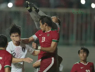 Kiper Timnas Indonesia, Awan Seto (kanan) menghalau bola dari kejaran pemain Korea Selatan U-23 pada laga uji coba di Stadion Pakansari, Bogor, (23/6/2018).  Indonesia U-23 kalah 1-2 dari Korea U-23. (Bola.com/Nick Hanoatubun)