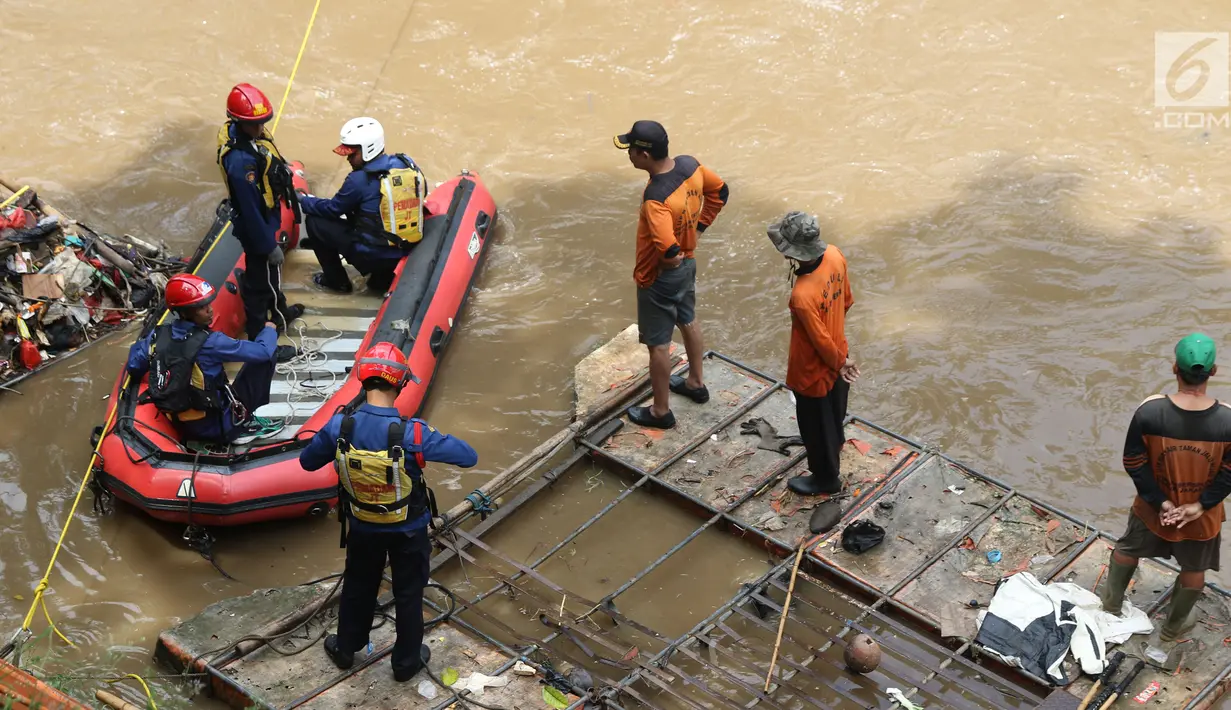 Petugas SAR dari unsur Damkar PB bersama petugas PPSU melakukan operasi pencarian di Kalibaru, Jakarta, Kamis (20/12). Operasi pencarian terkait informasi adanya orang tenggelam di Kalibaru, Pasar Rebo, Jakarta Timur. (Liputan6.com/Helmi Fithriansyah)