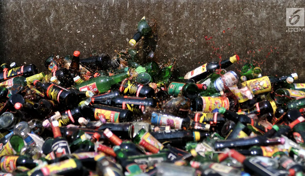 Ribuan botol minuman keras (miras) ilegal dihancurkan dengan menggunakan alat berat di Lapangan Silang Monas Tenggara, Jakarta, Senin (27/5/2019). Pemprov DKI memusnahkan 18.174 botol miras tanpa izin hasil penertiban periode Januari 2019 hingga Mei 2019. (merdeka.com/Iqbal S Nugroho)
