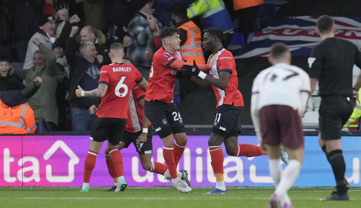 Selebarasi para pemain Luton Town setelah Elijah Adebayo (kanan) mencetak gol ke gawang Manchester City pada laga pekan ke-16 Liga Inggris 2023/2024 di Kenilworth Road, Luton, Minggu (10/12/2023) malam WIB. (AP Photo/Kin Cheung)