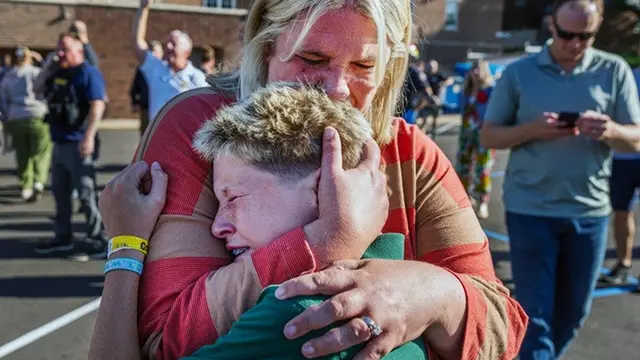 Seorang orang tua memeluk putranya pasca tragedi penembakan massal di Sekolah Katolik Annunciation di Minneapolis, Minnesota, Amerika Serikat, Rabu (27/8/2025).