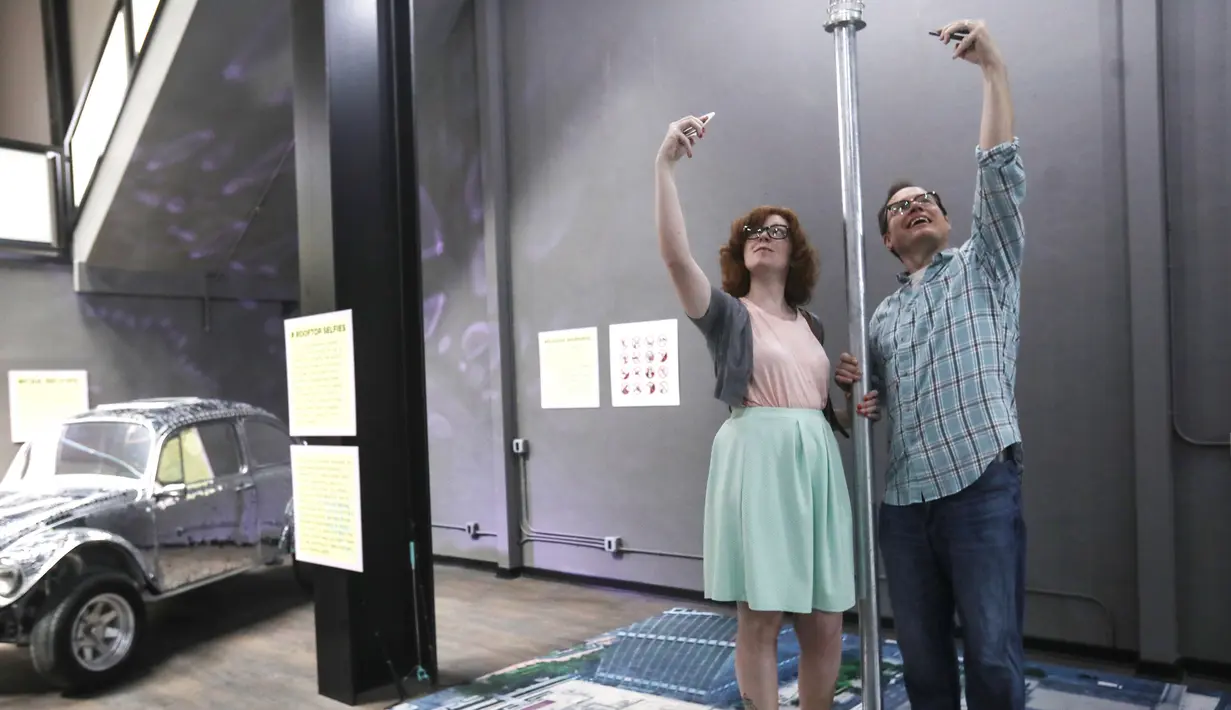 Pengunjung berswafoto pada pembukaan Museum of Selfies di Glendale, California, Minggu (1/4). Pameran di museum ini bersifat interaktif dan juga memberikan banyak informasi soal sejarah, serta perkembangan budaya selfie. (Mario Tama/Getty Images/AFP)