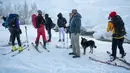 Turis Prancis dan Italia berinteraksi dengan imigran yang akan menuju perbatasan antara Italia dan Prancis di Pegunungan Alpen, Italia (13/1). Mereka berjalan kaki melintasi dinginnya salju untuk menuju perbatasan Italia dan Prancis. (AFP/Piero Cruciatti)