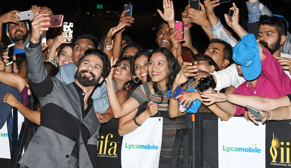 Aktor Shahid Kapoor berswatafoto dengan penggemar pada malam penghargaan IIFA 2017 di Stadion MetLife, East Rutherford, New Jersey, Minggu (16/7). Ajang penghargaan IIFA sering mendapat julukan Oscar Bollywood dari para penggemarnya. (AP/Charles Skykes)