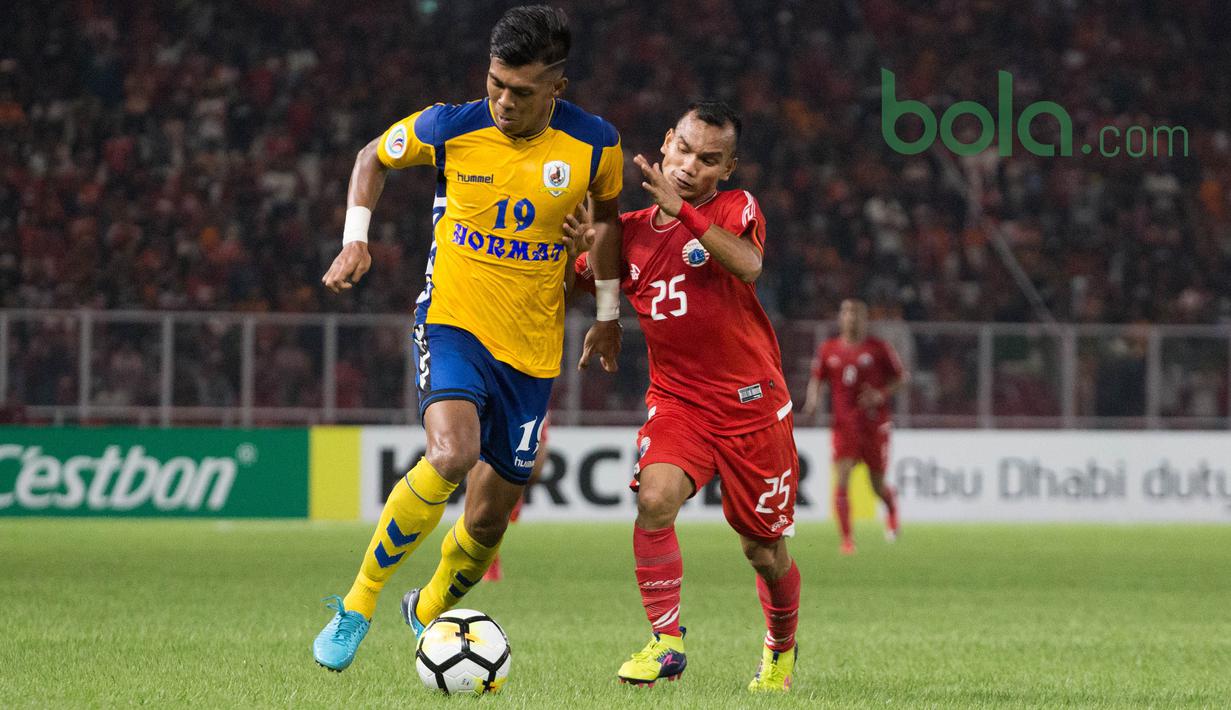 Pemain Persija Jakarta, Riko Simanjuntak berebut bola dengan pemain Tampines Roversdi Lapangan Utama Gelora Bung Karna, Jakarta, Rabu (28/2/2018). Persija Jakarta menang 4-1 atas Tampines Rovers pada AFC Cup grup H. (Bola.com/Asprilla Dwi Adha)