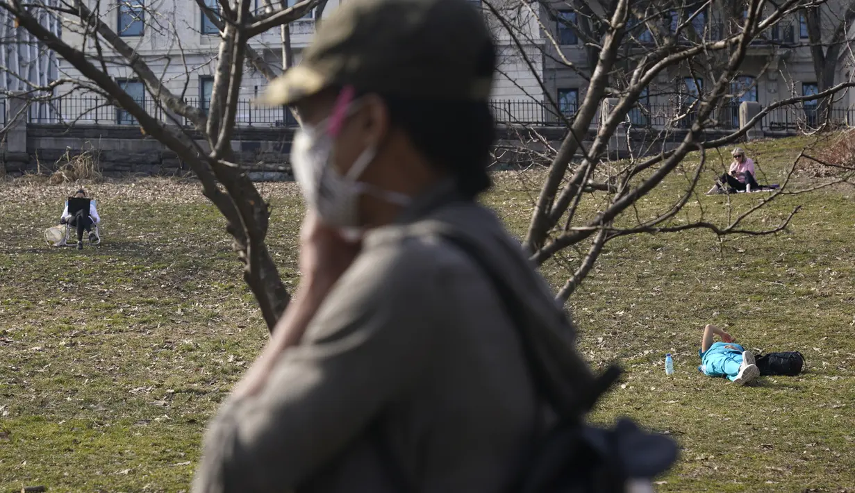 Orang-orang bersantai di rerumputan di Morningside Park di New York (11/3/2021).  Cuaca hangat yang tidak wajar membuat warga New York keluar setelah awal tahun bersalju. (AP Photo / Seth Wenig)