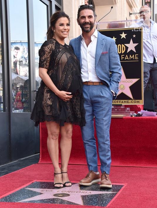 Eva Longoria dan suami, Jos Baston berdiri di atas bintang Hollywood Walk of Fame miliknya saat acara penghargaan di Los Angeles, Senin (16/4). Eva Longoria merupakan penerima bintang ke-2.634 di kategori Televisi (Alberto E. Rodriguez/GETTY IMAGES/AFP)