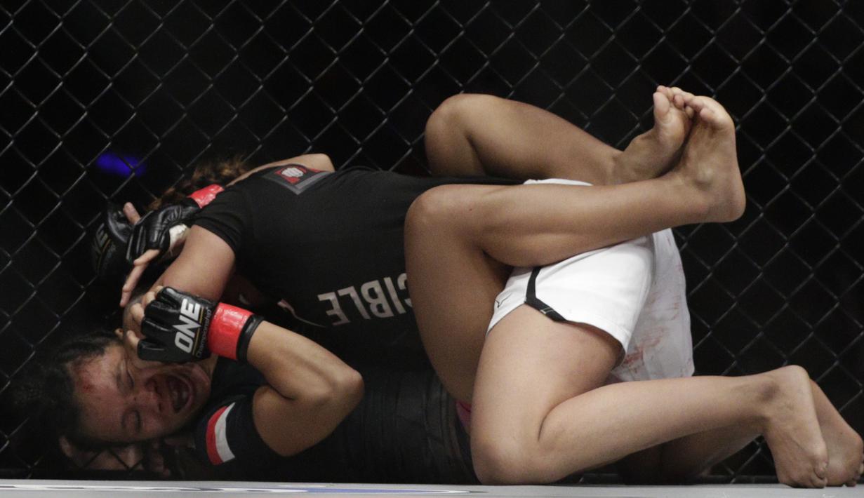 Petarung Indonesia, Priscilla Lumban Gaol, mengunci petarung India, Puja Tomar, saat bertarung pada laga ONE Championship di Istora Senayan, Jakarta, Sabtu (19/1). Priscilla kalah dari Puja. (Bola.com/M. Iqbal Ichsan)