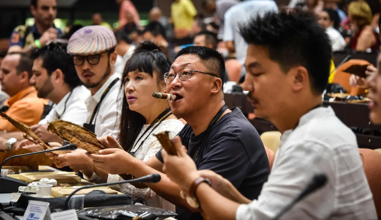 Sejumlah peserta menggulung cerutu selama kelas master dalam Festival Havana Cigar ke-20 di Istana Konvensi di Havana, Kuba (28/2). (AFP Photo/Adalberto Roque)