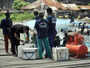 Seorang petugas dari Direktorat Kepolisian Perairan Polda Sulsel, memeriksa barang bukti bom ikan beserta tersangka nelayan pemiliknya di Makassar, Sulsel, Rabu (18/4). (Antara)