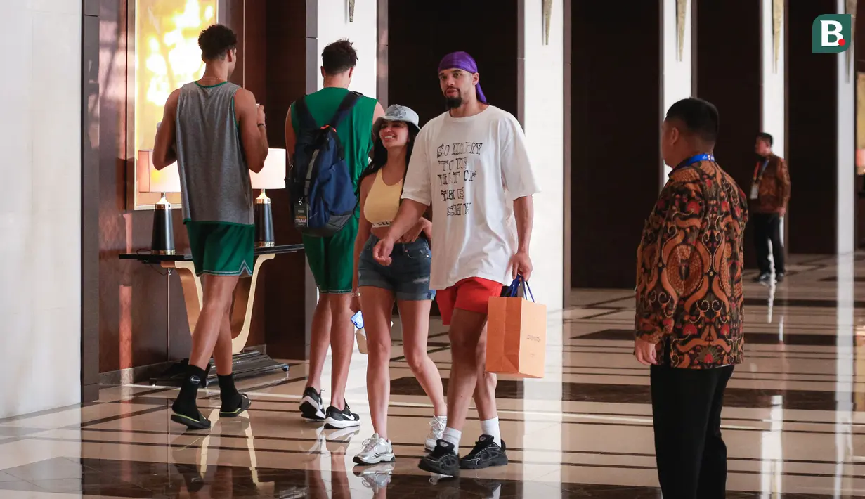 Pebasket Kanada, Dillon Brooks (tengah kanan) berjalan bersama sang kekasih, Danielle atau yang dikenal Big Bambina sambil membawa bungkusan di lobi hotel mereka menginap pada Kamis (24/08/2023). (Bola.com/Bagaskara Lazuardi)