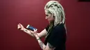 Hanna Washlake mendengarkan tato gelombang suara yang mengeluarkan pesan dari ibunya di Black Raven Tattoo California, 12 April 2018. Soundwave Tattoo menghasilkan suara berdurasi satu menit yang berasal dari pola gelombang audio. (AFP/FREDERIC J. BROWN)