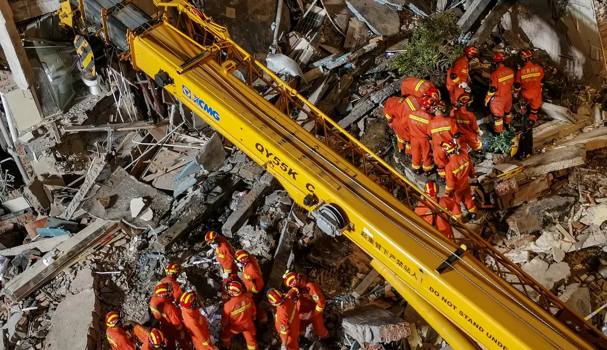 Petugas penyelamat sedang menggali sisa-sisa hotel yang runtuh untuk mencari korban selamat  di Suzhou di Provinsi Jiangsu, China timur (12/7/2021). Insiden itu menyebabkan setidaknya satu orang tewas dan 10 lainnya hilang, lapor kantor berita negara CCTV. (AFP/CNS)