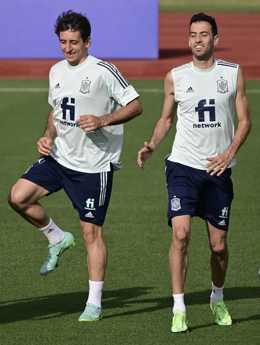 Pemain depan Spanyol Mikel Oiarzabal (kiri)  dan gelandang Sergio Busquets berlari selama sesi latihan di Ciudad del Futbol di Las Rozas dekat Madrid (3/7/2021). Spanyol merengkuh tiket semifinal Euro 2020 usai menang 5-2 atas Swiss lewat babak penalti.  (AFP/Javier Soriano)