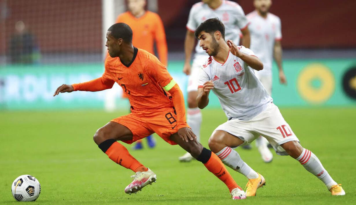 Pemain Belanda, Georginio Wijnaldum, berusaha melewati pemain Spanyol, Marco Asensio, pada laga uji coba di Johan Cruyff Arena, Rabu (11/11/2020). Kedua tim bermain imbang 1-1. (Dean Mouhtaropoulos via AP Photo, Pool)