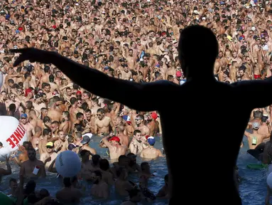 Orang – orang menari sambil di iringi musik pada pesta kolam air di Festival Circuit Vilassar de Dalt, Barcelona, Spanyol, Senin (11/8/2015). Sekitar 8.000 kaum gay dan lesbian meramaikan Festival ini. (REUTERS/Albert Gea)