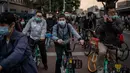 Orang-orang yang memakai masker untuk mengurangi risiko tertular virus corona COVID-19 sedang menunggu di lampu merah saat mereka bepergian dengan sepeda selama jam sibuk di Beijing, China pada 14 Oktober 2020. (Photo by NICOLAS ASFOURI / AFP)