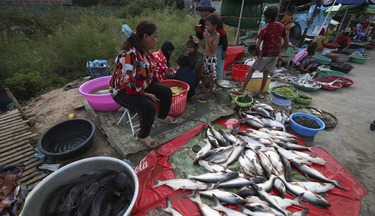 Etnis Vietnam menjual ikan di sepanjang trotoar dekat desa Prek Pnov di Phnom Penh, Kamboja, Kamis (5/8/2021). Prek Pnov terkenal dengan peternakan ikannya dan memasok banyak pasar di Phnom Penh. (AP Photo/Heng Sinith)
