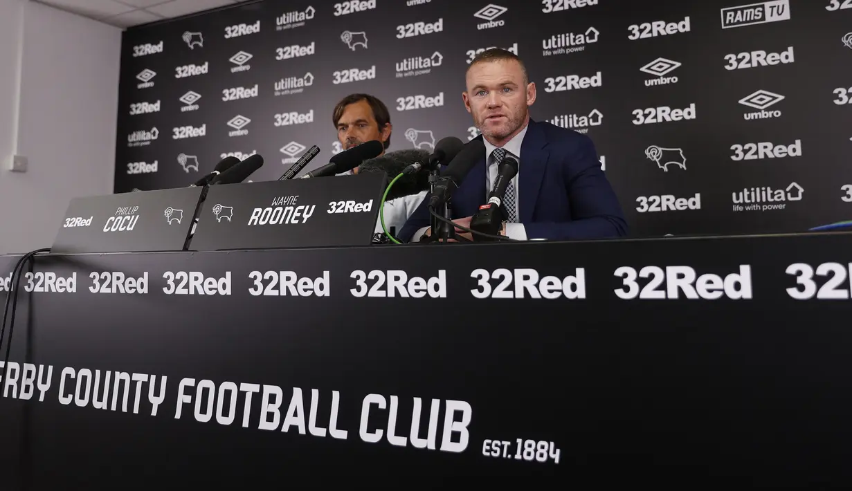Mantan kapten Inggris, Wayne Rooney dan Manajer Derby County Phillip Cocu memberikan keterangan saat konferensi pers di Stadion Pride Park, pinggiran kota Derby, Selasa (6/8/2019). Rooney resmi bergabung dengan klub kasta kedua Liga Inggris Derby County sebagai pemain-pelatih. (Darren STAPLES / AFP)