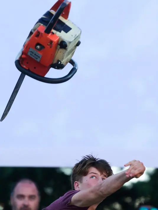 Gergaji mesin melayang setelah dilempar peserta saat mengikuti Kejuaraan Lempar Chainsaw ke-4 di Kocevje, Slovenia (1/7). (AFP Photo/Jure Makovec)