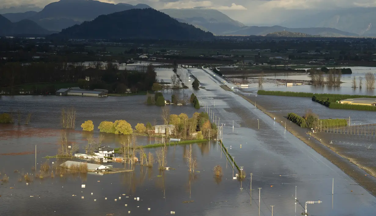 Air banjir yang naik mengelilingi sebuah rumah dan menutupi Highway 1 di Abbotsford, British Columbia, Kanada, Selasa (16/11/2021).  Walikota Abbotsford Henry Braun mengatakan jalan raya tidak dapat dilewati menciptakan kekacauan di kotanya. (Jonathan Hayward/The Canadian Press via AP)