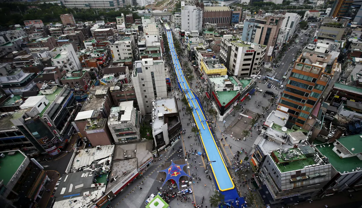 Seluncuran air dengan panjang 350 meter (1.148 kaki), acara yang bertajuk City Slide Festa 2015 di pusat kota Seoul, Korea Selatan, Minggu (19/07/2015). Seluncuran air dengan panjang 350 meter ini merupakan yang terpanjang di Korea. (REUTERS/Kim Hong-Ji)