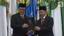 Menteri Dalam Negeri Tito Karnavian (kanan) bersama pejabat lama Tjahjo Kumolo memegang berita acara serah terima jabatan di Kantor Kemendagri, Jakarta, Rabu (23/10/2019). Presiden Jokowi resmi melantik Tito Karnavian menjadi mendagri dalam jajaran Kabinet Indonesia Maju. (merdeka.com/Imam Buhori)