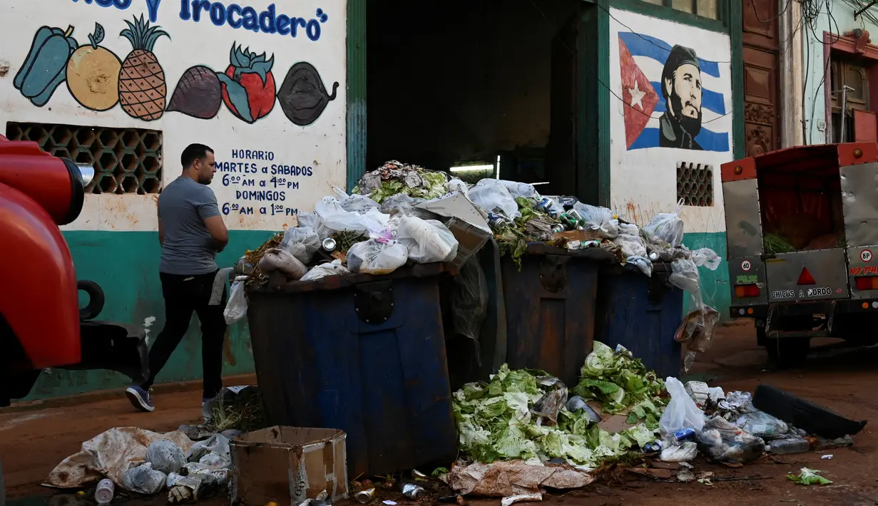 Karena kurangnya tempat sampah, penduduk meninggalkan kantong sampah mereka di jalan, memperburuk bau busuk yang berasal dari pipa pembuangan yang meluap. (YAMIL LAGE / AFP)