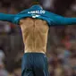 Pemain Real Madrid, Cristiano Ronaldo mengenakan kembali jerseynya seusai melakukan selebrasi di hadapan suporter Camp Nou pada leg pertama Piala Super Spanyol, Senin (14/8). Laga itu berakhir dengan skor 3-2 bagi Barcelona. (STRINGER/AFP)