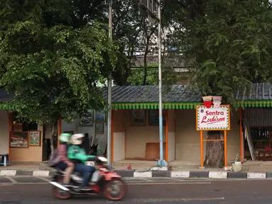 sepeda motor melintasi lapak kios di Sentra Lukisan Pasar Baru, Jakarta, Jumat (16/11). Sejumlah seniman lukis mengeluhkan kondisi lapak Sentra Lukisan Pasar Baru. (Liputan6.com/Immanuel Antonius)