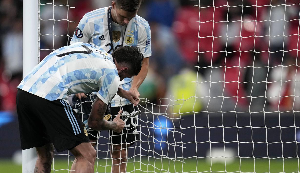 Pemain Argentina, Rodrigo De Paul (kiri) dan Giovani Lo Celso memotong jaring gawang setelah memenangkan laga Finalissima melawan Italia dengan skor 3-0 di Stadion Wembley, Kamis (02/06/2022) dini hari WIB. Gol La Albiceleste masing-masing dicetak oleh Lautaro Martinez (28'), Angel Di Maria (45+1'), dan Paulo Dybala (90+4'). (AP/Matt Dunham)