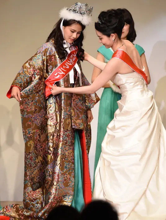 Mika Matsuno (kiri) menerima selempang dari Miss Nippon sebelumnya saat dinobatkan menjadi pemenang Miss Nippon 2016 di Tokyo, Jepang (25/1). Miko merupakan putri dari politikus Jepang Yorihisa Matsuno. (AFP PHOTO/Toshifumi Kitamura)